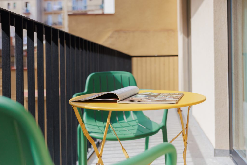 Yellow table and green chair on a private balcony at Gavà.