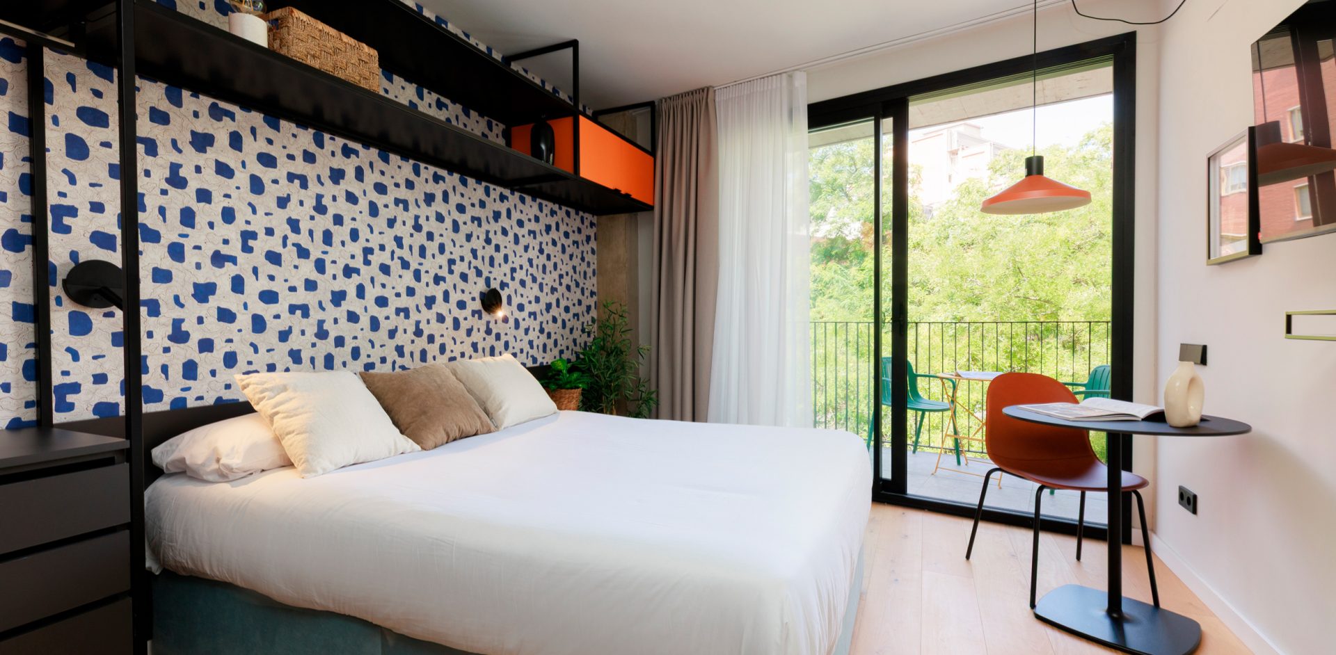 Furnished Gavà apartment with a double bed, patterned headboard and balcony.