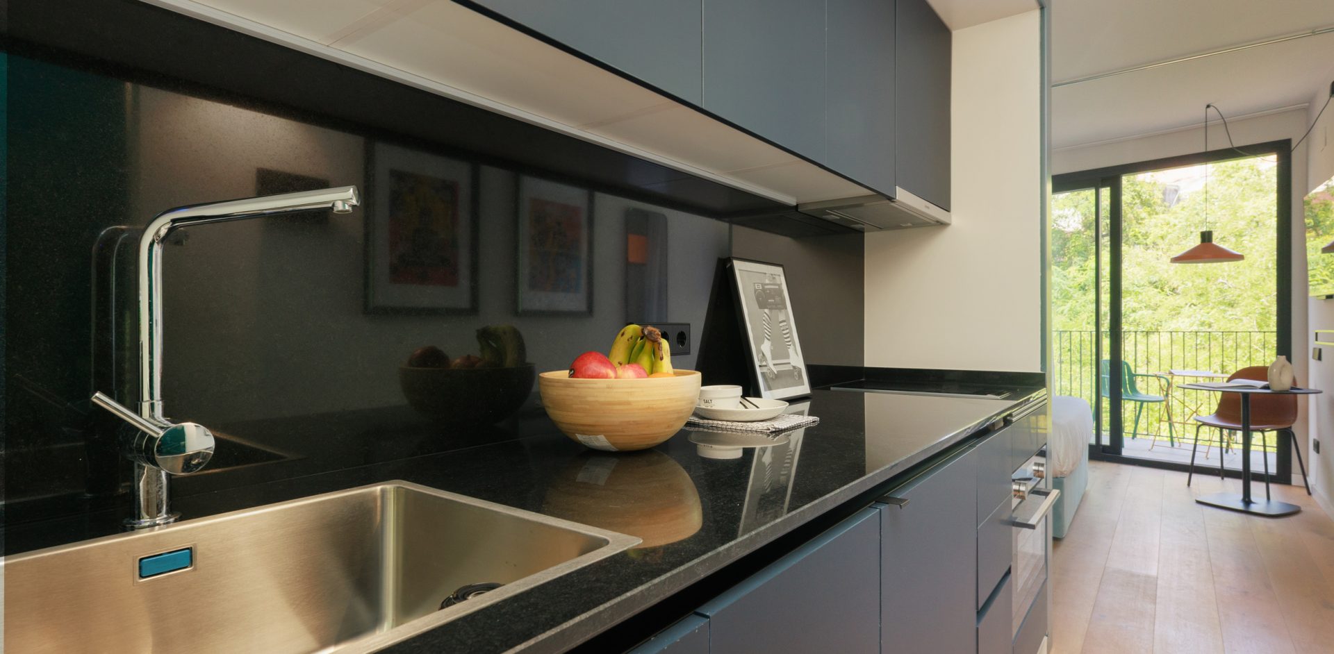 Private kitchen with dark cabinets, a dining area and balcony access at Gavà.